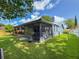 Exterior view of screened-in patio with lush backyard and mature trees on a sunny day at 7444 119Th Ave, Largo, FL 33773
