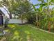 Spacious backyard featuring lush lawn, garden beds, and mature trees, enhancing privacy at 7444 119Th Ave, Largo, FL 33773