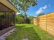 Backyard view with a privacy fence, lush green lawn, and mature trees providing ample shade at 7444 119Th Ave, Largo, FL 33773