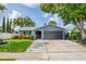 Beautiful single-story home featuring well-maintained landscaping, a gray two-car garage, and an American flag at 7444 119Th Ave, Largo, FL 33773
