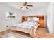 Bright main bedroom features wood floors, a ceiling fan, a built-in headboard, and a bright window at 7444 119Th Ave, Largo, FL 33773