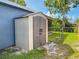 Backyard shed with double doors, a fenced enclosure, and a tree providing partial shade in the background at 7444 119Th Ave, Largo, FL 33773