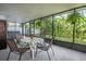 Bright sunroom has views of the greenery and includes a hot tub, chairs, and table at 7444 119Th Ave, Largo, FL 33773