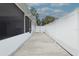 A long concrete walkway runs between the house and a tall white fence at 7503 Winchester Dr, Tampa, FL 33615
