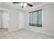 A bright bedroom with a ceiling fan, tiled floors, and a window with curtains at 7503 Winchester Dr, Tampa, FL 33615