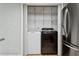 Convenient laundry area with washer, dryer, and storage shelving near stainless steel fridge at 7503 Winchester Dr, Tampa, FL 33615