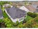 Aerial view of the home with a dark roof, a manicured lawn, a swing set, and a patio at 7616 Paradiso Dr, Apollo Beach, FL 33572