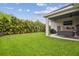 Spacious backyard featuring a covered patio with outdoor seating and lush green lawn at 7616 Paradiso Dr, Apollo Beach, FL 33572