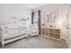 Charming Bedroom with a white crib, cozy chair, soft carpet and decorative accents at 7616 Paradiso Dr, Apollo Beach, FL 33572