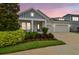 Charming single Gathering home with a three-car garage, inviting front porch, and beautiful landscaping at 7616 Paradiso Dr, Apollo Beach, FL 33572