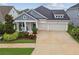Charming single Gathering home with a three-car garage, inviting front porch, and beautiful landscaping at 7616 Paradiso Dr, Apollo Beach, FL 33572