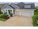 Charming single Gathering home with a three-car garage, inviting front porch, and beautiful landscaping at 7616 Paradiso Dr, Apollo Beach, FL 33572