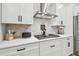 Kitchen with stainless steel appliances, herringbone backsplash, and white cabinets and countertops at 7616 Paradiso Dr, Apollo Beach, FL 33572