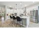 Bright eat-in kitchen with white cabinetry, stainless appliances, tile backsplash and center island with pendant lighting at 7616 Paradiso Dr, Apollo Beach, FL 33572