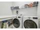 Modern laundry room with front-load washer and dryer and ample shelving for storage at 7616 Paradiso Dr, Apollo Beach, FL 33572