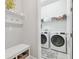 Well-organized laundry room featuring a bench, shelving, and modern washer and dryer at 7616 Paradiso Dr, Apollo Beach, FL 33572
