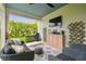 Inviting outdoor patio with comfortable seating, a ceiling fan, TV, and view of the backyard at 7616 Paradiso Dr, Apollo Beach, FL 33572