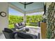 Relaxing covered patio featuring a lounge area, swing, and view of lush greenery at 7616 Paradiso Dr, Apollo Beach, FL 33572