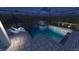 Backyard pool area with glass fence, lounge chairs, and nighttime lighting offers a private oasis at 7616 Paradiso Dr, Apollo Beach, FL 33572