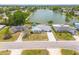 Aerial view of a home with a well-manicured lawn and a lake in the background at 8014 Lotus Dr, Port Richey, FL 34668