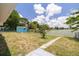 Spacious backyard with a shed and a concrete path leading to the lake at 8014 Lotus Dr, Port Richey, FL 34668