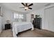 Bright bedroom featuring a ceiling fan, neutral carpet, and a comfortable bed with a dark dresser at 8014 Lotus Dr, Port Richey, FL 34668