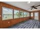 Inviting sunroom with lake views from many windows and featuring stylish floors and a ceiling fan at 8014 Lotus Dr, Port Richey, FL 34668