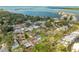 An aerial view showcases a residential neighborhood with mature trees and lush green surroundings near the waterfront at 8335 42Nd N Ave, St Petersburg, FL 33709