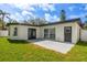 Exterior home view showcasing the back patio with dark-framed doors and windows, complemented by the green lawn at 8335 42Nd N Ave, St Petersburg, FL 33709