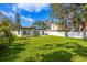 Spacious, grassy backyard with white fence bordering the property, and a view of the home's exterior at 8335 42Nd N Ave, St Petersburg, FL 33709