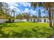 Expansive backyard view featuring lush green grass, privacy fence, and a charming exterior view of the home at 8335 42Nd N Ave, St Petersburg, FL 33709