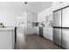 Modern kitchen featuring white cabinets, stainless steel appliances, quartz counters, and wood grain floors at 8335 42Nd N Ave, St Petersburg, FL 33709