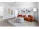 Bright living room featuring an orange couch, a round ottoman, wood floors, and modern decor at 8335 42Nd N Ave, St Petersburg, FL 33709