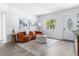 Bright living room featuring an orange couch, a round ottoman, modern decor, and a front door at 8335 42Nd N Ave, St Petersburg, FL 33709