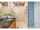 Modern bathroom with a glass-enclosed shower, granite countertop, and dual sinks, offering a spa-like experience at 9806 Bennington Dr, Tampa, FL 33626