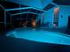 Inviting pool area featuring lounge chairs, screen enclosure, and ambient lighting for relaxing evenings at 9806 Bennington Dr, Tampa, FL 33626