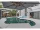 Beautiful view of the screened-in pool with lounge chairs, table set, and outdoor lighting for evening enjoyment at 9806 Bennington Dr, Tampa, FL 33626