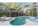 Inviting screened-in pool area with lounge chairs and an umbrella-covered table, perfect for outdoor relaxation at 9806 Bennington Dr, Tampa, FL 33626