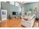 Bright living room with hardwood floors, a soaring ceiling, and a modern, oversized ceiling fan at 9806 Bennington Dr, Tampa, FL 33626
