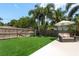 Manicured backyard with lush, green artificial turf and outdoor furniture under a patio umbrella at 1 Mandarin Ter, Safety Harbor, FL 34695