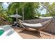 Serene backyard with a hammock, comfortable seating, and tropical landscaping by the pool at 1 Mandarin Ter, Safety Harbor, FL 34695