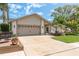 Beautifully landscaped front yard with a cozy outdoor seating area and a well-maintained two-car garage at 1 Mandarin Ter, Safety Harbor, FL 34695