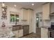 Bright kitchen featuring white cabinetry, stainless steel appliances, and granite countertops at 1 Mandarin Ter, Safety Harbor, FL 34695