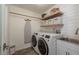 Bright laundry room featuring new washer and dryer, storage shelves, sink and shiplap accent wall at 1 Mandarin Ter, Safety Harbor, FL 34695