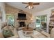 Comfortable living room featuring a stone fireplace and views of the inviting outdoor pool at 1 Mandarin Ter, Safety Harbor, FL 34695