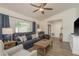 Inviting living room featuring a comfortable blue leather sofa, ceiling fan, and lots of natural light at 1 Mandarin Ter, Safety Harbor, FL 34695