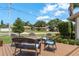 Inviting outdoor deck features comfortable seating around a fire pit, surrounded by lush landscaping and mature trees at 1 Mandarin Ter, Safety Harbor, FL 34695