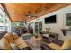 Relaxing covered patio with wicker furniture, wood ceiling, and views of the backyard at 1 Mandarin Ter, Safety Harbor, FL 34695