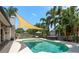 Beautiful pool with sunshade, hot tub, and lush tropical landscaping for a relaxing backyard oasis at 1 Mandarin Ter, Safety Harbor, FL 34695
