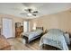 Neutral-toned bedroom featuring two twin beds, wooden floors, and a ceiling fan at 11187 Blythville Rd, Spring Hill, FL 34608